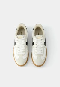 Pair of white sneakers with black accents and brown soles, viewed from above on a plain white background.