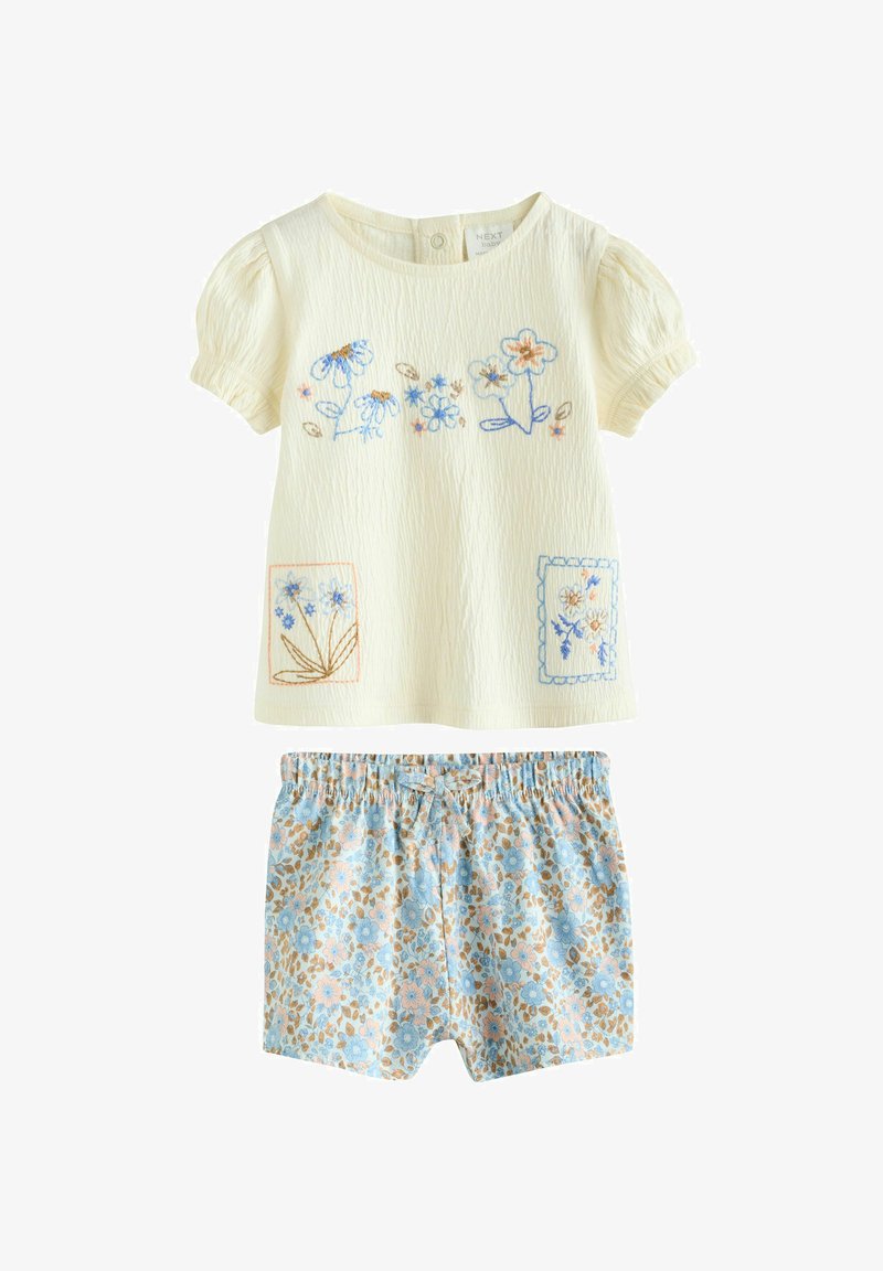 Cream short-sleeve baby top with blue and orange floral embroidery and blue floral printed shorts with elastic waist and bow.