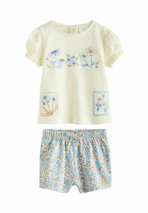 Two-piece children's outfit with a light yellow textured top featuring floral embroidery, paired with blue patterned shorts.