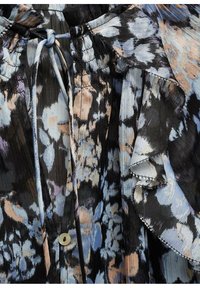 Floral blouse with black, blue, and peach patterns, featuring a cinched neckline, ruffled sleeves, and a single button closure. Textured fabric.