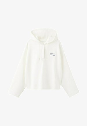 Bela kapucarja s kapuco, dolgimi rokavi in vrvicami, z majhnim črnim napisom na prsih: »Potovanje morja, peska in sonca«.