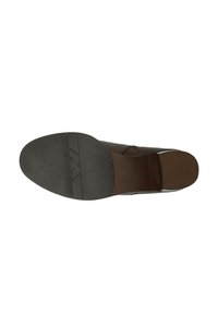 Suola in pelle marrone con una texture nera per una presa ottimale, dettagli intricati vicino al tallone e una forma slanciata e arrotondata.