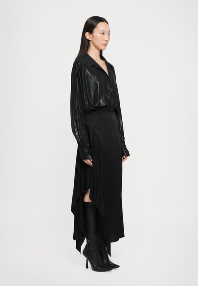 Black long-sleeve blouse with a high collar, paired with a flowing black maxi skirt featuring a high slit, and knee-high black stiletto boots.