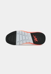Talpă de sneaker din cauciuc negru și gri cu accente portocalii; prezintă un model texturat pentru aderentă și secțiuni modelate distincte pentru flexibilitate.
