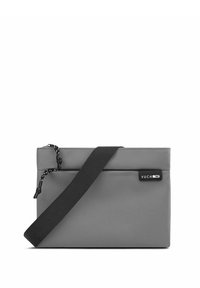 Šedá crossbody taška z odolné látky, vybavená zipovým uzávěrem, nastavitelným popruhem a malou značkovou štítek na přední straně.