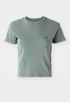 Ribbetud, lühikeste varrukatega särk helesinisel tooni, millel on ümmargune kaelus ja väike logo märk rinnal. Pehme, tekstureeritud kangas.