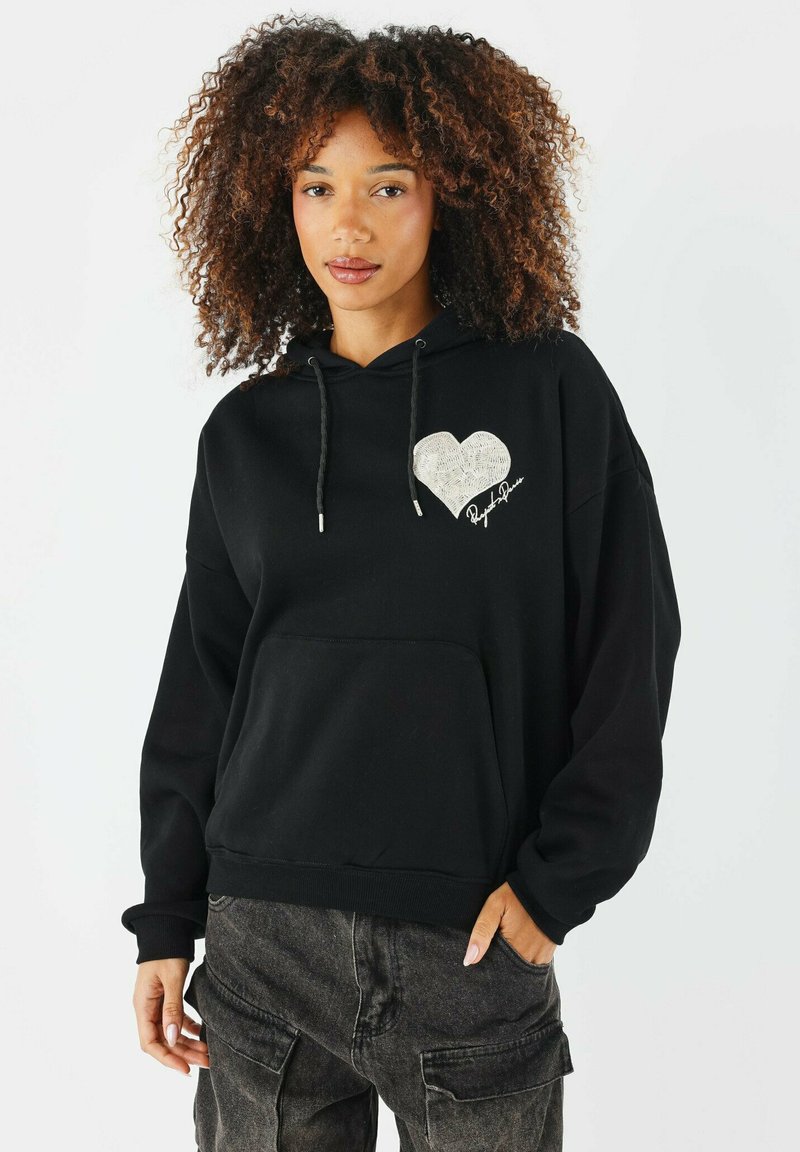 Felpa nera con tasca frontale, cappuccio con cordino e design a forma di cuore bianco con dettagli texture. Vestibilità casual con maniche lunghe.