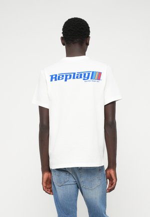 Hvit bomull T-skjorte med en blå "Replay" logo og teksten "RACING TEAM 1981" på baksiden. Standard rund hals og korte ermer.