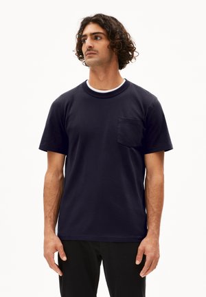 Marineblauwe katoenen t-shirt met korte mouwen, een ronde halslijn en een borstzakje. Zachte textuur en een relaxte pasvorm.