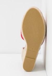 Semelle d'une chaussure compensée espadrille pour femme avec une semelle extérieure en caoutchouc texturé, taille 4, et une bordure en jute raffia naturel.