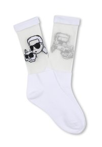 Calzini bianchi con un motivo a maglia che presenta un grafico di una figura con occhiali da sole e un design di teschio su un lato, e un contorno di veicolo sull'altro.