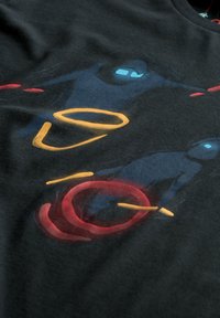 T-shirt in cotone nero con grafica astratta di due figure in blu e rosso, arricchita da accenti circolari arancioni e gialli. Tessuto morbido, vestibilità classica.