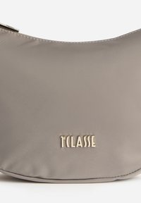 Borsa a spalla grigia in nylon con una texture liscia e forma curva. Presenta un logo metallico "TCLASSE" sul davanti.