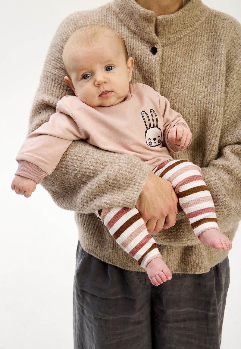 Rosa långärmad tröja med kaninmotiv, kombinerad med ribbade randiga leggings i rosa, brunt och vitt. Mjuka texturerade material.