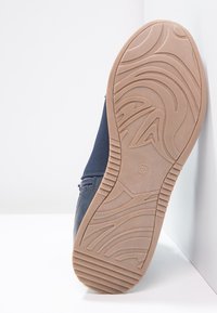 Marinståhl blå sko med en slät yta, utrustad med en sidodragkedja och en strukturerad beige gummisul, storlek 37.