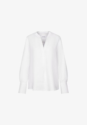 Blouse blanche à manches longues avec un col en V, sans col et avec de larges poignets, présentée sur un fond blanc uni.