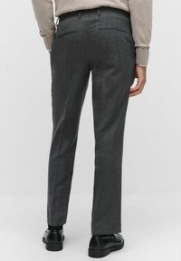 Grå skräddarsydda byxor med en slät yta, slim fit och tv�å bakfickor. Bärs med svarta skor.