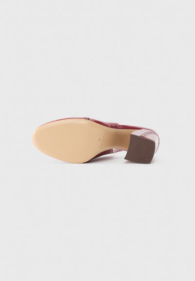 Red patent leather shoe with a square heel. The sole is beige, featuring embossed brand name. Closure detail includes a zip on the side.