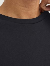 Camiseta azul marino con cuello redondo, hecha de suave tela de algodón, con una textura lisa y costuras mínimas alrededor del cuello.