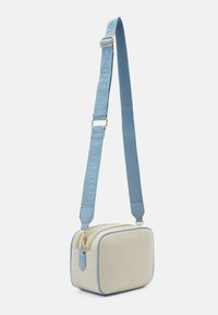 Beige textilväska med blå detaljer och ett logoband. Har en rektangulär form, dragkedjestängning och detaljer i guld.