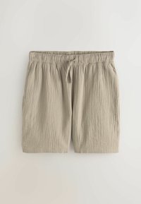 Világos bézs színű, texturált szövetből készült rövidnadrág rugalmas derékpánttal és elöl húzózsinórral, síkban elhelyezve egyszínű fehér háttéren.