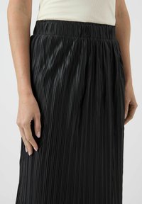 Sort plisseret nederdel med elastisk taljebånd, der har strukturerede lodrette linjer og en glat, blank stofoverflade.