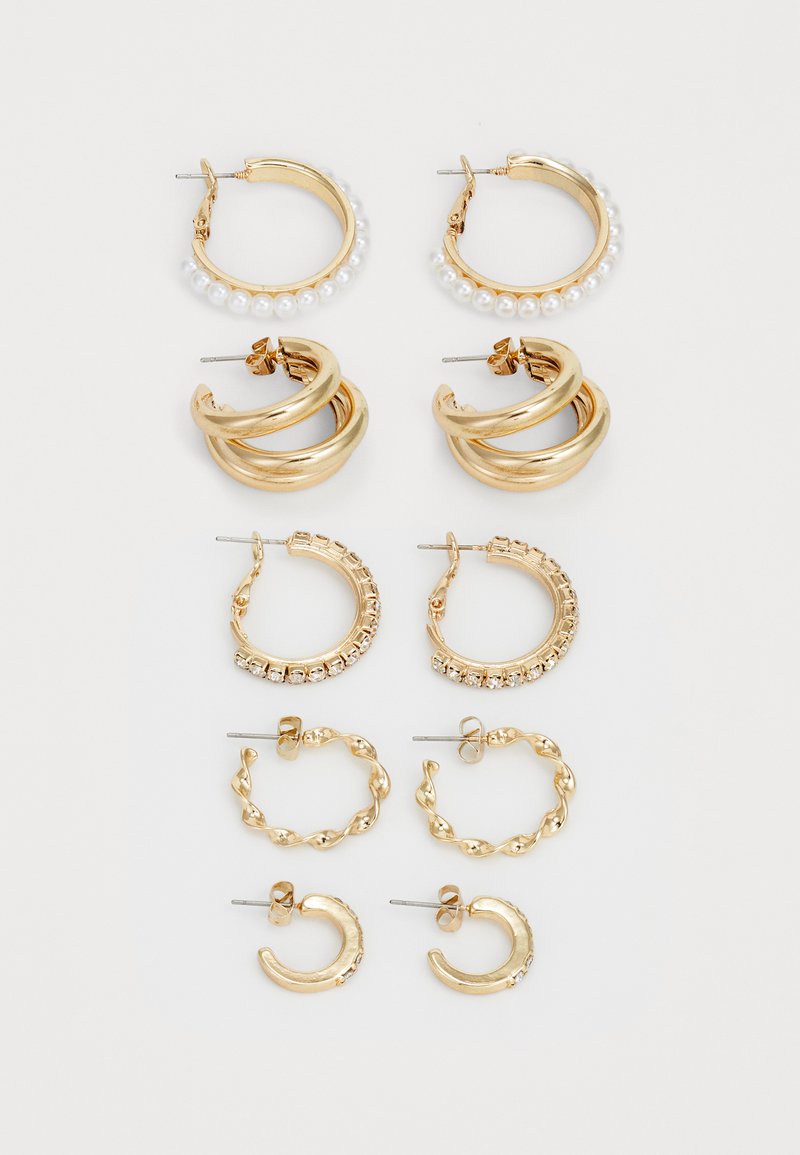 Conjunto de brincos dourados com diversos designs: argolas com pérolas, argolas torcidas e estilos adornados com strass em vários tamanhos.