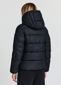 Giacca a vento nera imbottita con pannelli trapuntati orizzontali, colletto alto con cappuccio e finitura in tessuto lucido e liscio.