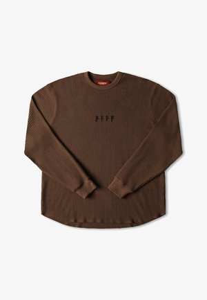 Haut en tricot à manches longues marron avec un tissu texturé, col rond et poignets côtelés. Il présente un petit logo noir sur la poitrine. Ourlet arrondi.