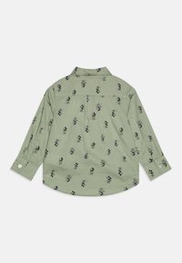Camicia verde a maniche lunghe con un motivo ripetuto di Topolino nero, polsini con bottoni e un dettaglio nella parte posteriore. Tessuto morbido.
