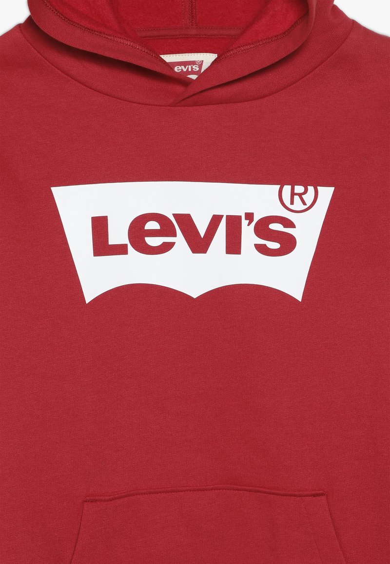 Czerwona bluza z kapturem wykonana z mieszanki bawełny, z dużym białym logo Levi's z przodu. Wzór zawiera kieszeń kangurzą oraz kaptur ze sznurkiem.