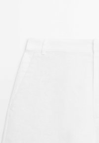 Witte linnen broek met een gladde textuur, platte tailleband en zijzakken. Het ontwerp is eenvoudig en biedt een schone, minimalistische uitstraling.