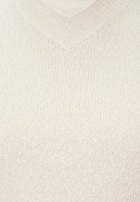 V-Ausschnitt-Pullover aus weichem, hellbeigem Strickstoff mit strukturiertem Muster, ausgestattet mit gerippten Kanten am Halsausschnitt.