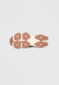 Semelle de sneaker avec un motif circulaire et en forme de diamant, présentant une base beige et des accents en caoutchouc marron. Texturée pour une meilleure adhérence et durabilité.