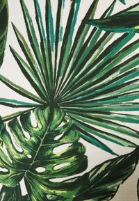 Feuilles tropicales vertes de palmier et de monstera avec des nuances variées sur un fond clair, formant un motif botanique dense et naturel.