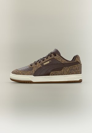Καφέ αθλητικό παπούτσι Puma με λεπτομέρειες λεοπάρδαλης, σκουρόκαυστη ρίγα και λευκή σόλα, εμφανιζόμενο από το πλάι σε ουδέτερο φόντο.