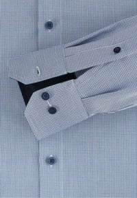 Hemd in Navy- und Weiß-Karos, mit strukturiertem Stoff, gebogenen Manschetten und dunklen Knöpfen.