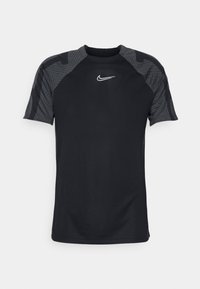 Camiseta atlética negra con mangas cortas tipo raglán, con acentos grises texturizados y el logo blanco de Nike en el pecho. Tejido suave y transpirable.