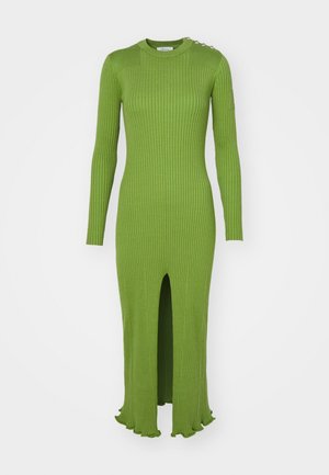 Ribbed, long-sleeve green dress with a round neck, side slit, and scalloped hem. Features decorative hardware on the shoulder.