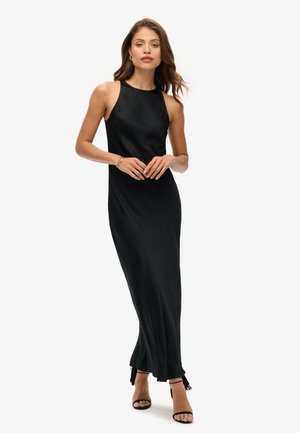 Robe de soirée en satin noir avec un design sans manches, coupe longue, fentes latérales avec des franges et une silhouette épurée.