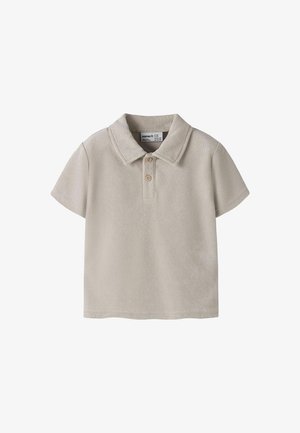 Polo de manga corta para niño pequeño en tela de rizo beige con dos botones de madera y cuello doblado.