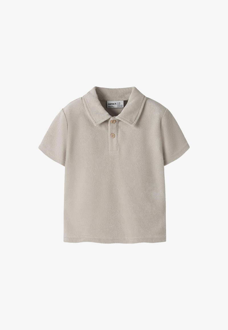 Polo à manches courtes pour tout-petit en tissu éponge beige avec deux boutons en bois et col plié.
