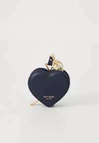 Herztasche aus dunkelblauem Leder mit goldenen Akzenten und einem Schlüsselanhänger; mit Branding auf der Vorderseite.