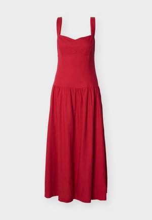 Robe midi rouge avec larges bretelles, corsage ajusté et jupe froncée sur un fond blanc uni.