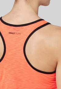 Camiseta deportiva naranja con ribete negro, que presenta un diseño de corte racerback y un pequeño logo impreso en la parte posterior cerca del escote.