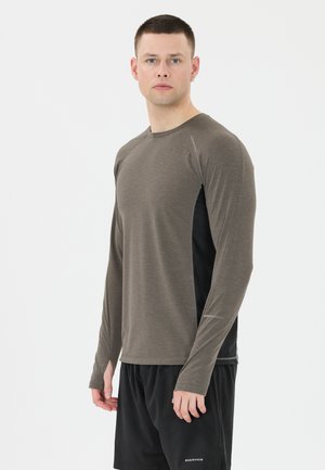 Langsleevige sportshirt in donkerbruin met zwarte zijpanelen. Heeft een ronde halslijn en een zachte textuur, ontworpen voor comfort tijdens activiteiten.