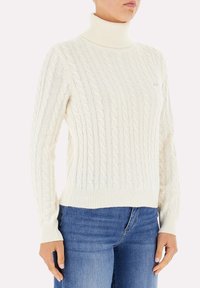 Maglione girocollo bianco a coste con maniche e orlo a coste, caratterizzato da un motivo testurizzato e una silhouette slim. Abbinato a jeans blu.