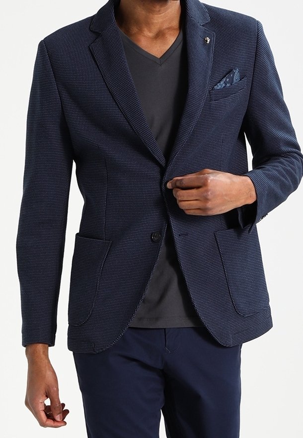 Granatowa marynarka o fakturowanej powierzchni, z dwoma przednimi kieszeniami i poszetką. Lekka tkanina, dopasowany krój, bez widocznych zapięć.