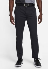 Svarta golfbyxor med slim fit, tillverkade av mjukt tyg. Har midja i standardhöjd och slät framsida. Kombineras med svarta träningsskor.