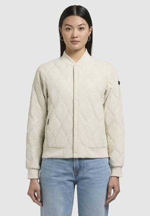 Beige gewatteerde bomberjack met een staande kraag, nauwsluitende manchetten en zijzakken. Beschikt over een gestructureerd oppervlak en een decoratief embleem op de mouw.